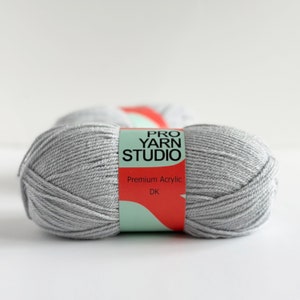 May include: A skein of light gray yarn labeled "Pro Yarn Studio" with the words "Premium Acrylic" and "DK" on the label.