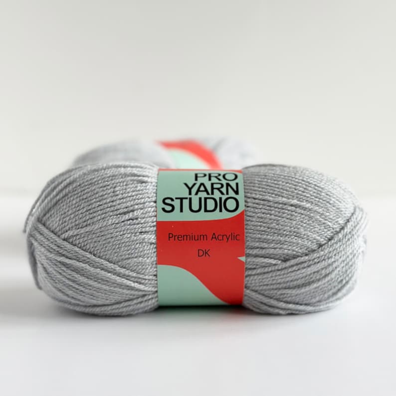 May include: A skein of light gray yarn labeled "Pro Yarn Studio" with the words "Premium Acrylic" and "DK" on the label.