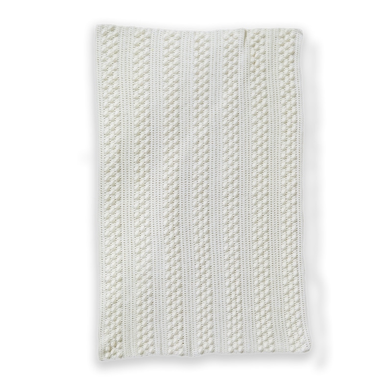 May include: A white crocheted throw blanket with a textured pattern of vertical stripes.