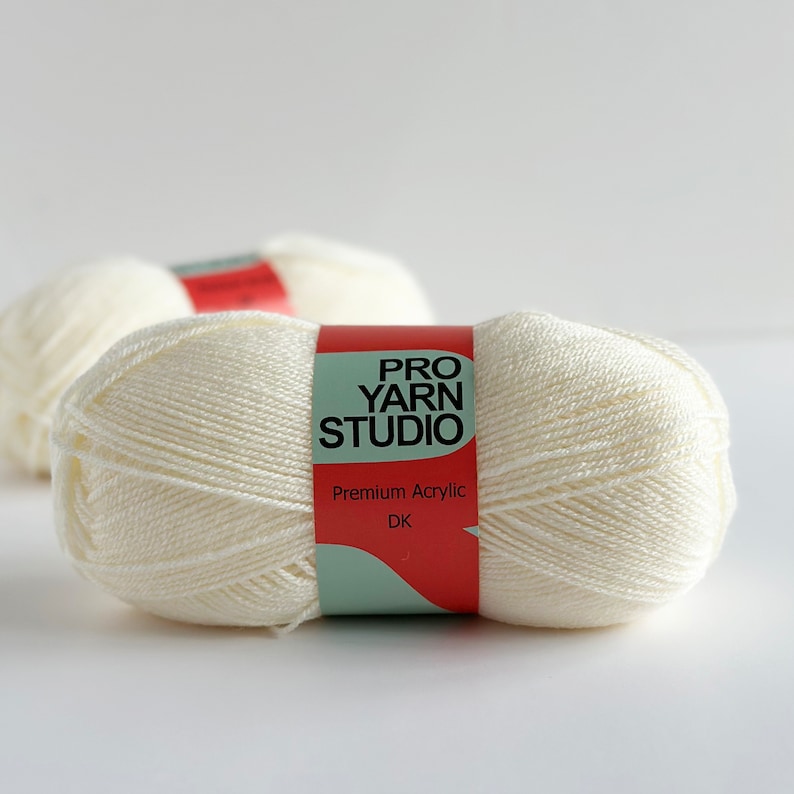 May include: Two balls of white yarn with a red and green label that reads "PRO YARN STUDIO" and "Premium Acrylic DK".