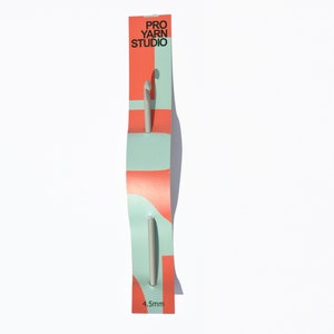May include: A silver crochet hook with a red and blue packaging card. The card has the text "PRO YARN STUDIO" and "4.5mm".