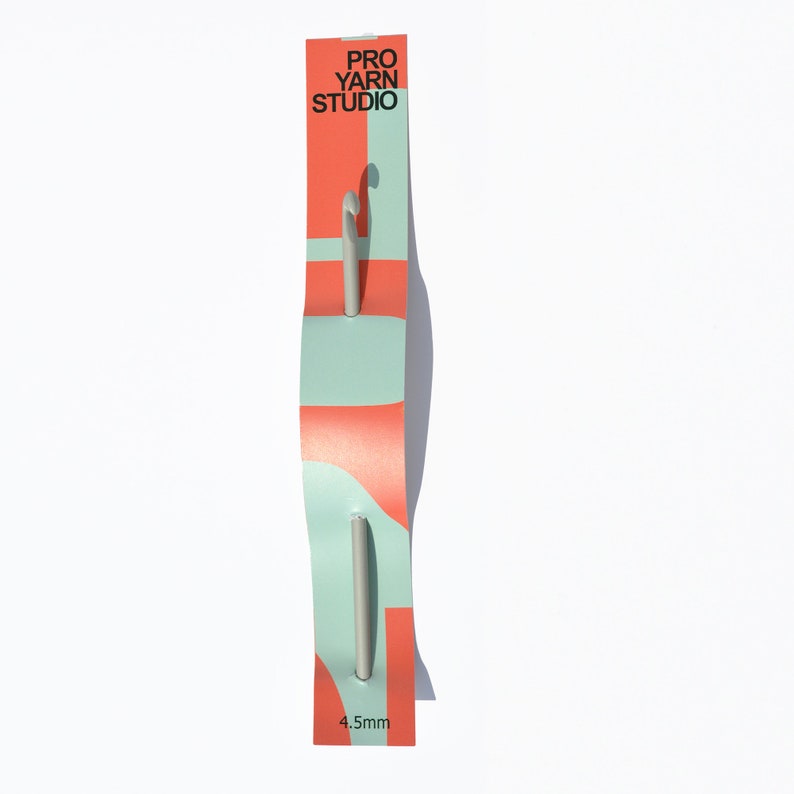 May include: A silver crochet hook with a red and blue packaging card. The card has the text "PRO YARN STUDIO" and "4.5mm".