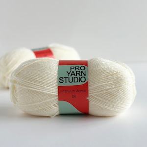 May include: Two balls of white yarn with a red and green label that reads "PRO YARN STUDIO" and "Premium Acrylic DK".