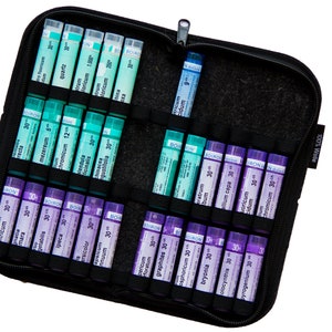 Op de afbeelding: Een zwarte ritszak met een verscheidenheid aan kleine glazen flesjes die homeopathische remedies bevatten. De flesjes zijn gelabeld met verschillende namen en nummers. De tas is gelabeld met "100% Wallet".
