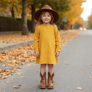 Könnte beinhalten: Eine weiße Keramik-Tasse mit schwarzem Henkel und dem Text "But First, Coffee" in schwarzer, fetter Schrift. Die Tasse steht auf einer Holzoberfläche. Die Tasse ist etwa 10 cm hoch.