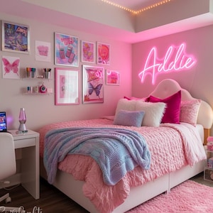 May include: A bedroom featuring a bed with a pink textured comforter, a light blue knit throw blanket, and various pillows. A neon sign on the wall displays the name Addie in pink. The walls are decorated with framed butterfly art and prints.
