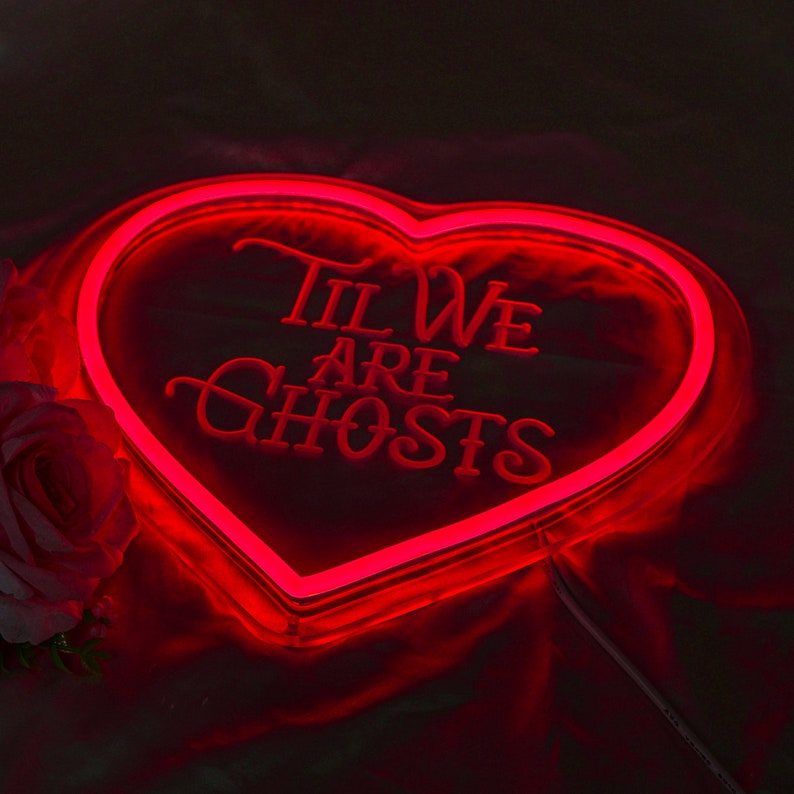 May include: Red neon heart-shaped sign with the text "Til We Are Ghosts" in a cursive font.