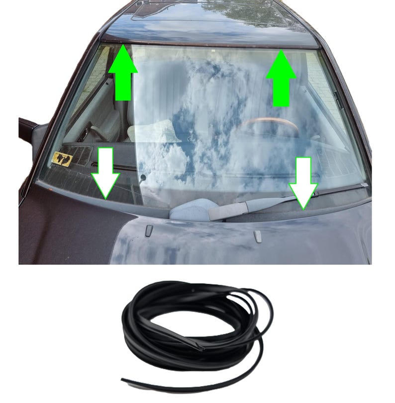 May include: A black rubber windshield seal coiled at the bottom of the image, with a car windshield in the background. The windshield has green arrows pointing to the seal's placement. The car's interior is visible through the glass, with a steering wheel.