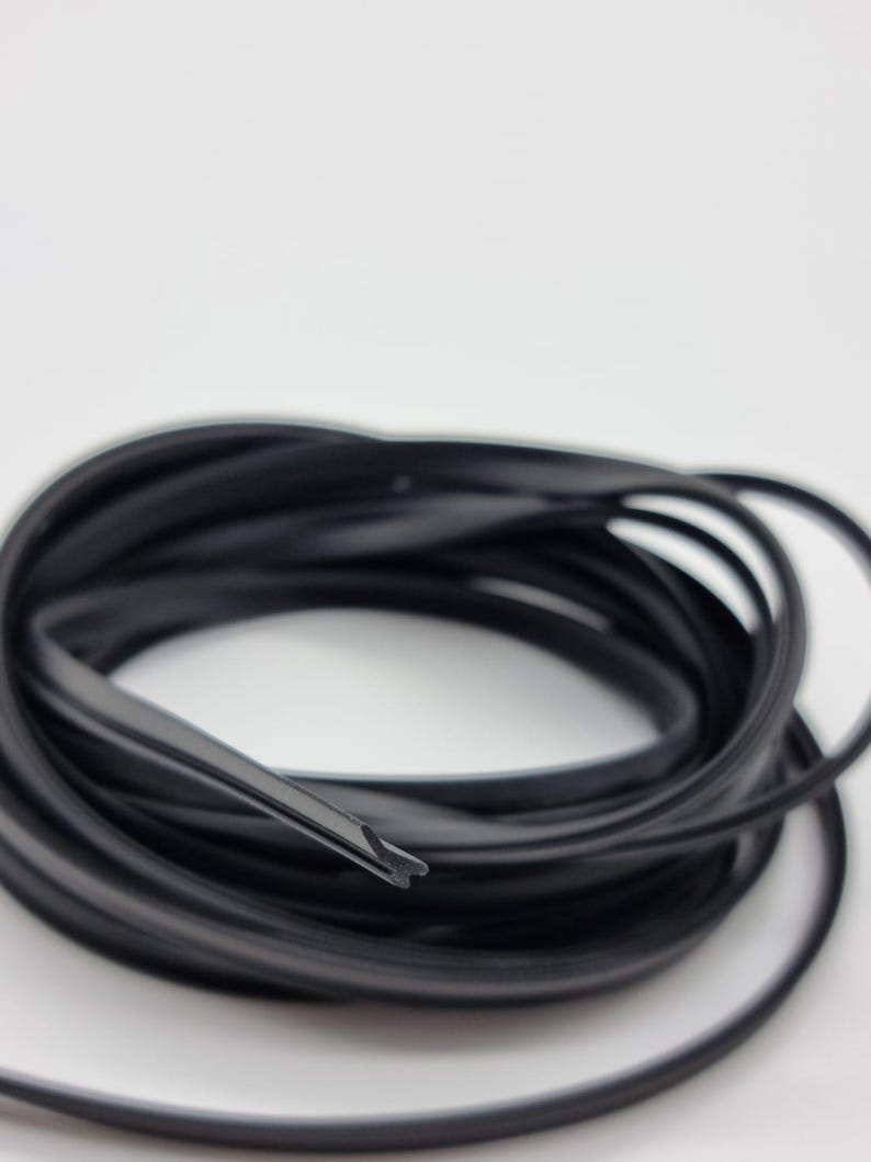 May include: Coiled black rubber weather stripping, ideal for sealing windows and doors. The flexible material is designed to create a tight seal, preventing drafts and moisture from entering. The weather stripping is shown against a white background.