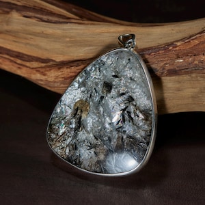 Pendentif en cristal de natrolite arc-en-ciel avec murmanite et aegirine des montagnes arctiques.