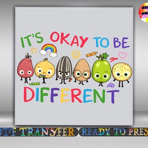 May include: A light gray graphic print featuring the text IT'S OKAY TO BE DIFFERENT in multicolored letters. The design includes six cartoon characters: a red potato, a yellow onion, a sunflower seed, a brown egg, a green grape, and a donut.