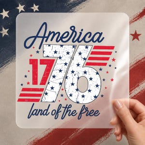 May include: A square transparent sticker featuring the text America 1776 land of the free in blue script and bold font. The number 76 is white with blue stars and a distressed texture, flanked by red horizontal stripes and small red stars.