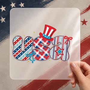 May include: A design spelling "USA" in red, white, and blue, with stars, stripes, and plaid patterns. The letter "U" has stars, the "S" is plaid, and the "A" has stripes. A red, white, and blue Uncle Sam hat is included.