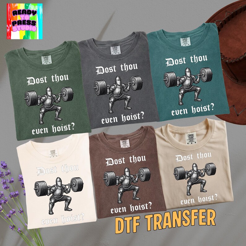 May include: Six different-colored t-shirts are displayed, each featuring a graphic of a knight lifting weights with the text "Dost thou even hoist?". The shirts are in shades of green, gray, brown, and cream, with the words "DTF TRANSFER" at the bottom.