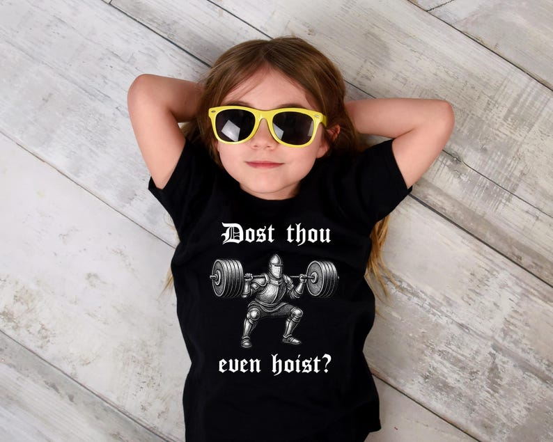May include: A black t-shirt featuring the phrase "Dost thou even hoist?" above a graphic of a knight lifting weights. The person in the image is wearing yellow sunglasses.