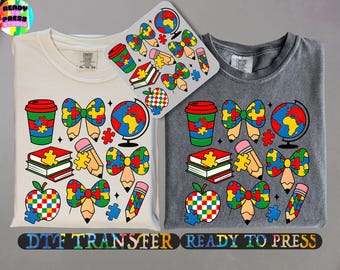 May include: Two t-shirts with a design featuring a globe, a coffee cup, a pencil, a book, an apple, and a bow made of puzzle pieces. The design is in a rainbow of colours. The text "DTG Transfer Ready to Press" is at the bottom of the image.