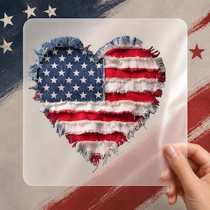 May include: A heart-shaped design featuring the American flag. The heart is made of denim and red and white fabric strips, with a frayed edge. The background has patriotic brushstrokes and stars.