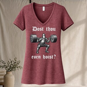 May include: Maroon V-neck t-shirt with the text "Dost thou even hoist?" above a graphic of a knight lifting a barbell. The graphic is in black and white.