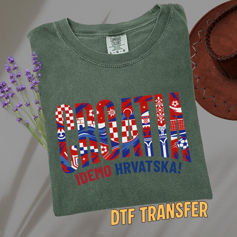 May include: A green Comfort Colors t-shirt with the word "CROATIA" in red, white, and blue patterned letters. The text "IDEMO HRVATSKA!" is below the word. The words "DTF TRANSFER" are in a yellow box at the bottom.