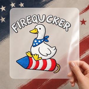 May include: A square clear sticker featuring a white duck with a yellow beak and feet, wearing a blue bandana with white stars. The duck sits on a red and white striped firework rocket. The text FIREQUUCKER is printed in black above the duck.