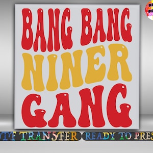 May include: A white background with the words "BANG BANG NINER GANG" in red and yellow bubble letters. The words are stacked vertically. Below the words is a black bar with the words "DTF TRANSFER READY TO PRESS" in colourful letters.