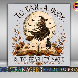 May include: A square graphic print featuring a witch flying on a broomstick in front of a full moon, with a black cat sitting on an open book below. The text reads TO BAN A BOOK IS TO FEAR ITS MAGIC, surrounded by autumn leaves, sunflowers, and bats.