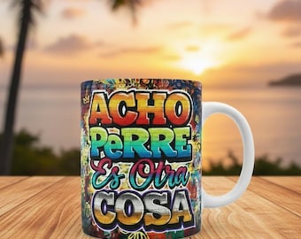 May include: White ceramic mug with a colorful graffiti design. The mug features the words "ACHO PERRE Es Otra COSA" in vibrant, layered lettering. The background shows a sunset over the ocean.