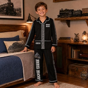 May include: A black long-sleeve pajama set featuring a white train track pattern along the button-down shirt and pants. The shirt displays the text BIG BOY and 4014, while the pants feature a train graphic and the text BIG BOY in white lettering.
