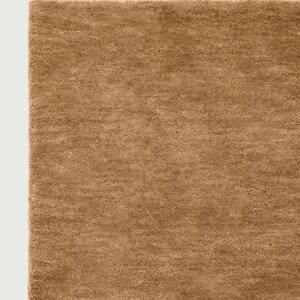 May include: A close-up of a rectangular, brown rug with a soft, textured surface. The rug has a plush appearance and is made of a dense material. The color is a warm, earthy tone, suitable for home decor.