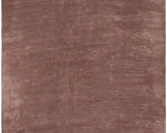 May include: A rectangular rug in a muted reddish-brown hue. The rug has a textured appearance with subtle variations in color, creating a soft, inviting look. The overall design is simple and elegant, suitable for various interior styles.