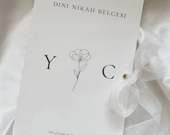 May include: A white card with the text "DINI NİKAH BELGESİ" at the top. The letters "Y" and "C" are on either side of a simple line drawing of a flower. The text "Sizi çiftler halinde yarattık." is at the bottom of the card.