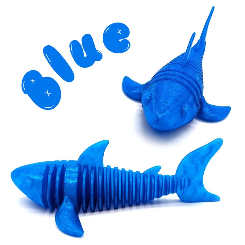 May include: Two blue shark toys and the word "blue" in a playful font. One shark is a detailed model with fins and a tail. The other shark has a streamlined design. The toys are on a white background.