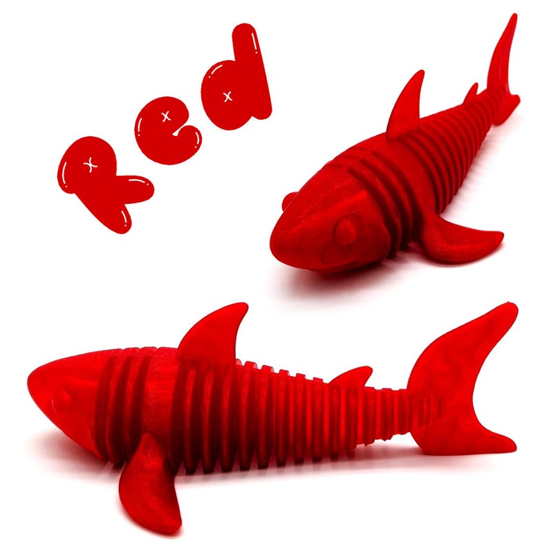 May include: Two red shark toys with a ribbed design are displayed on a white background. The word "red" is written in red, bubble-style letters. The sharks have fins and tails.