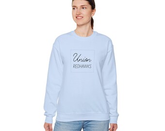 Pode incluir: Uma camisa de frio azul claro com um quadrado branco na frente que diz "Union Redhawks" em letras pretas.