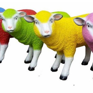 Puede incluir: Seis figuritas de ovejas de colores, cada una con un color de lana diferente: azul, rojo, verde, amarillo, rosa y blanco. Las ovejas están de pie en fila, mirando al espectador.