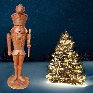 Könnte beinhalten: Eine Holz-Nussknacker-Figur steht in einer verschneiten Landschaft mit einem Weihnachtsbaum im Hintergrund. Der Nussknacker trägt eine traditionelle rot-goldene Uniform mit einem hohen Hut und einem Schnurrbart. Der Baum ist mit weißen Lichtern geschmückt.