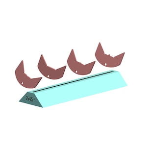 May include: Four brown ceramic pieces shaped like a cat's head, arranged on a light blue, angled surface labeled "2x45°".