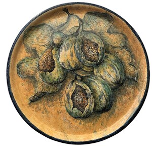 May include: A round ceramic plate with a hand-painted design of figs and leaves. The figs are in shades of green and yellow, with a detailed interior. The plate has a textured, tan background and a dark blue rim.