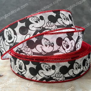 May include: Black and white ribbon with a red trim featuring a repeating pattern of Mickey Mouse faces.