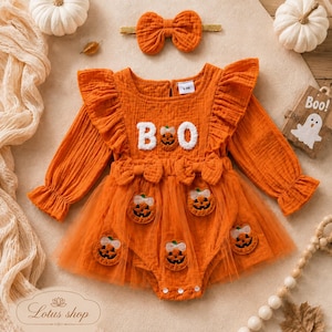 May include: An orange long-sleeved romper with ruffled shoulders, a tulle skirt overlay, and embroidered pumpkin patches. The chest features the white text "BOO" with a pumpkin replacing the letter O. Includes a matching orange hair bow.