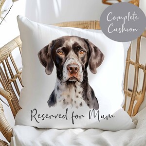 May include: White cushion cover featuring a watercolour illustration of a brown and white dog with the text "Reserved for Mum" printed at the bottom.