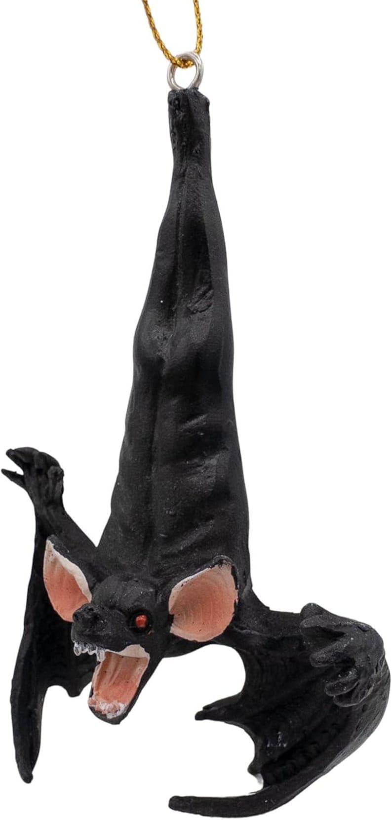 May include: A black hanging bat ornament with large pink ears, red eyes, and an open mouth showing white teeth. The bat is suspended by a thin gold string attached to a metal loop at the top of its head, featuring a textured body and wings.