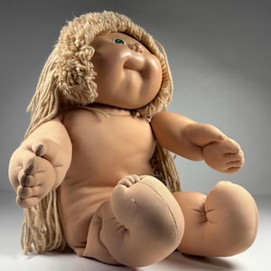 May include: A white ceramic mug with a black handle and the text "But first, coffee" in a black, handwritten-style font. The mug is on a white surface.