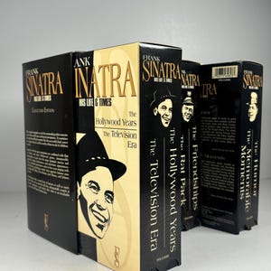 Puede incluir: Una colección de cintas VHS de Frank Sinatra. Las cajas son negras y beige con imágenes de Sinatra y texto que incluye "His Life & Times" y "The Hollywood Years". La colección incluye "The Television Era" y "The Memorable Moments".