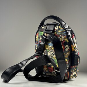 Puede incluir: Una mochila peque&ntilde;a con un estampado colorido de paneles de c&oacute;mic vintage de Mickey Mouse. El bolso cuenta con ribetes de piel sint&eacute;tica negra, un asa superior, correas de hombro ajustables de cinta negra y un cierre de cremallera lateral.