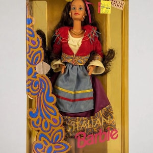 Puede incluir: Muñeca Barbie italiana de la colección Dolls of the World, en una caja transparente. La muñeca lleva una chaqueta roja, una falda azul y morada y una diadema amarilla. La caja tiene el texto "Dressed in a charming folk costume!" y "SPECIAL EDITION".