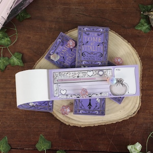 May include: A purple health tracking notepad titled The Tome of Vitality with a health bar, heart icons, and a pouch illustration. The notepad is displayed with several translucent multi-faceted dice and decorative purple card covers.