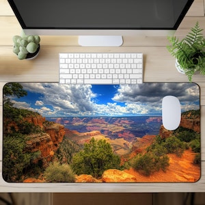 May include: A colorful mousepad featuring a panoramic view of the Grand Canyon. The image shows a vast, layered landscape with shades of red, orange, brown, and green. The mousepad is perfect for adding a touch of nature to your workspace.