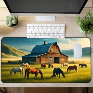 May include: A brown wooden barn with a blue roof sits in a grassy field with a rolling hill in the background.  There are several horses in the field, including brown, white, and black horses.