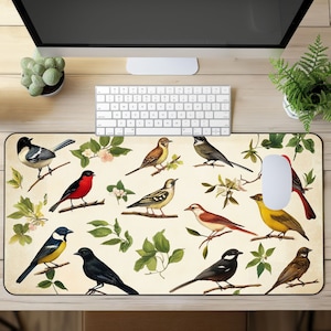 May include: A colorful mousepad with a white background and a pattern of various birds perched on branches with green leaves. The birds are in shades of red, yellow, blue, brown, and black.